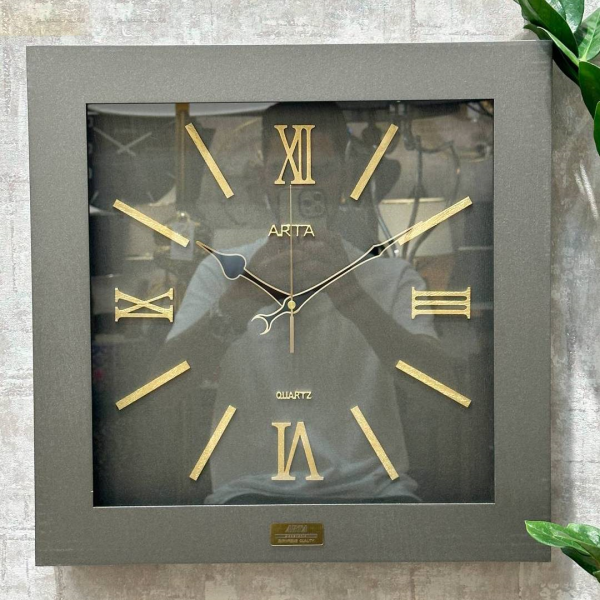  ساعت دیواری آرتا Arta کد 54، ساعت دیواری مربعی سایز 42 با اعداد رومی طلایی، متریال HDF طرح چوب، موتور روانگرد با ضمانت 3 ساله، رنگ طوسی