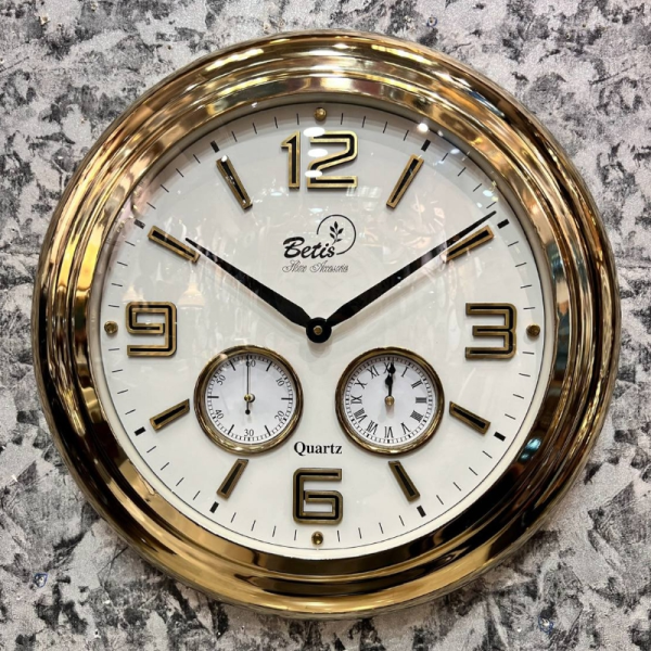 ساعت دیواری بتیس مدل 5040، ساعت دیواری سه موتوره مدرن با متریال فلز، رنگ آبکاری شده طلایی، موتور تایوانی با صفحه سفید و جزییات ظریف روی صفحه، دارای اعداد لاتین